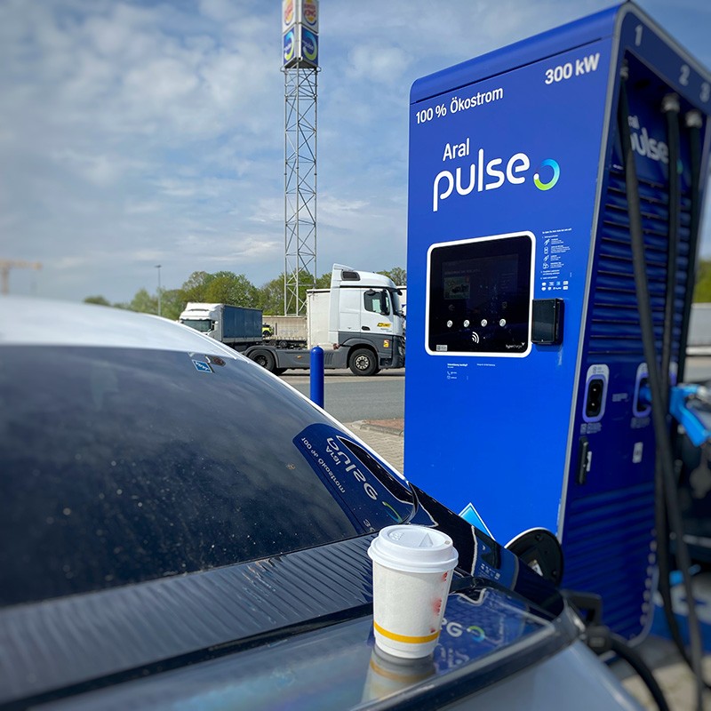 Elektro Zapfsäule mit Auto und Kaffee-Becher